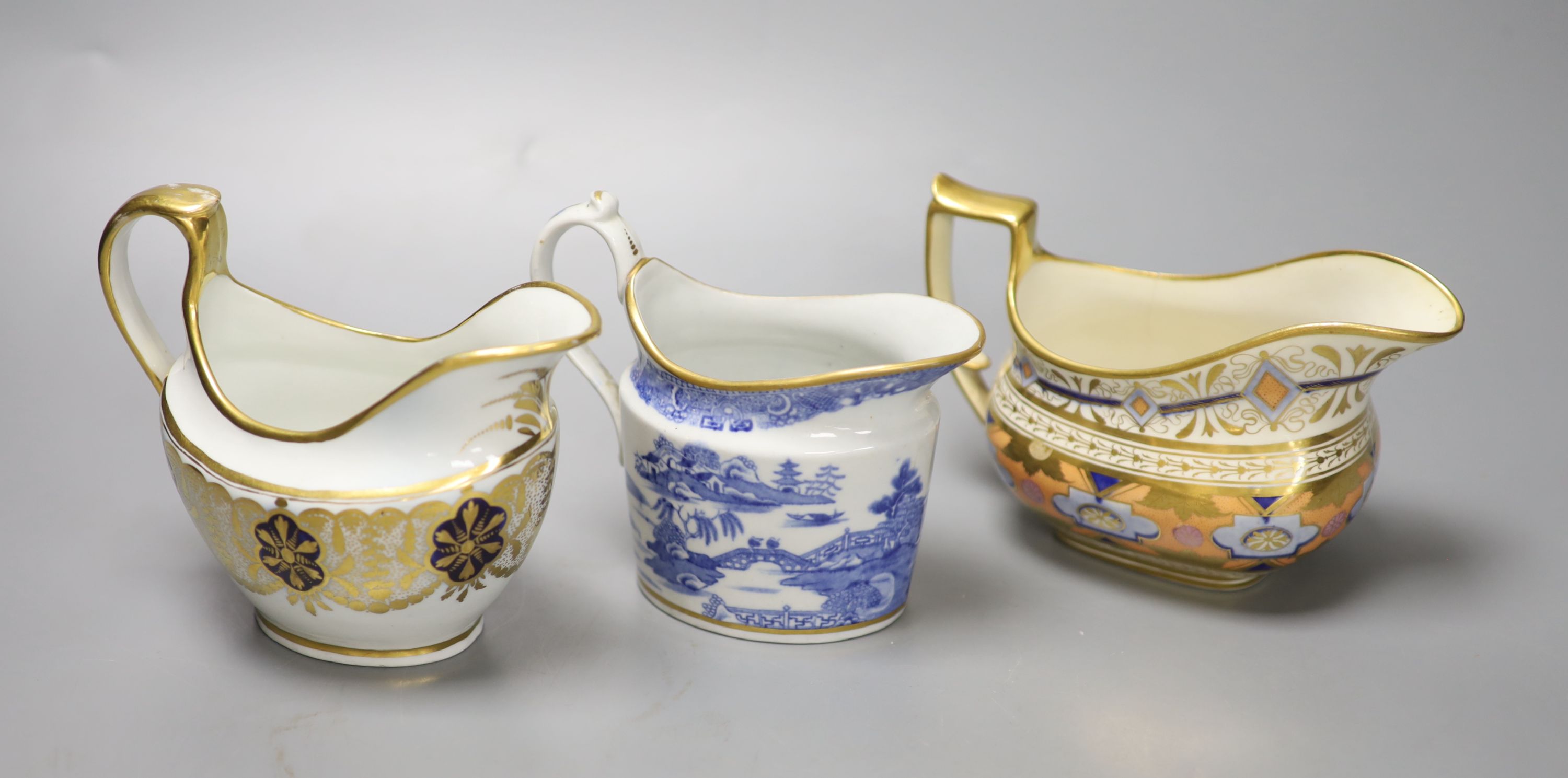 A Coalport hybrid hard paste cream jug in blue and gilt, a Miles Mason blue and gilt cream jug, impressed M. Mason, and a Ridgway cream